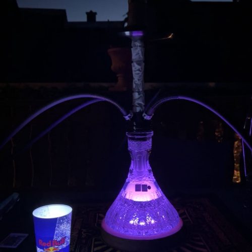 Shisha mit LED-Beleuchtung auf einem Balkon bei Nacht.