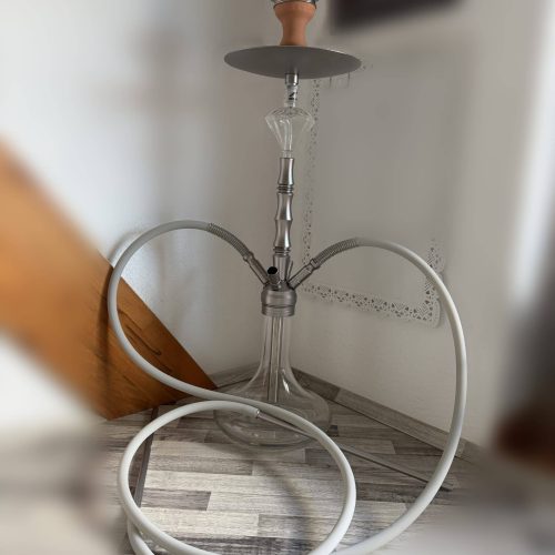 Shisha-Kopf mit Glasbowl und Schlauch, auf Boden stehend.
