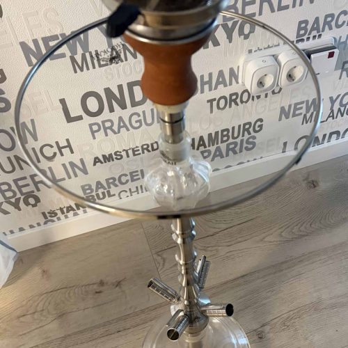 Shisha mit Glasbowl und Metallstange auf Holztisch.