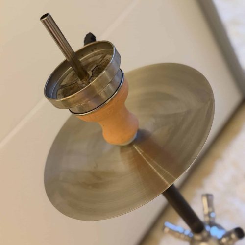 Shisha mit Metall- und Keramikteilen, rauchend auf einem Tisch.