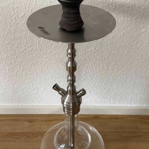 Shisha mit Glasbowl, Kopf und Schlauch auf Tisch.