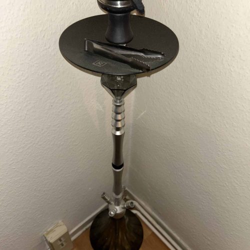 Shisha-Rauchsäule mit Zubehör auf einem Stand, in einer Ecke.