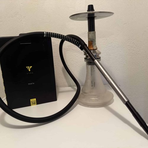 Shisha mit Glasbowl, Schlauch und Heizplatte auf Tisch.