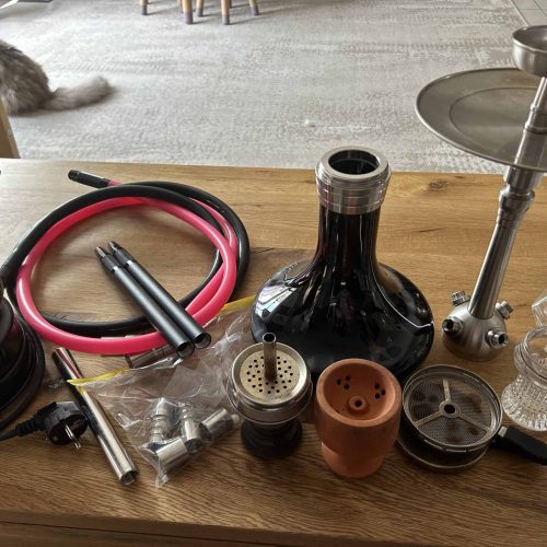 Vape- und Shisha-Accessoires, inklusive Schlauch, Kopf und Dampfgerät, auf Holztisch.