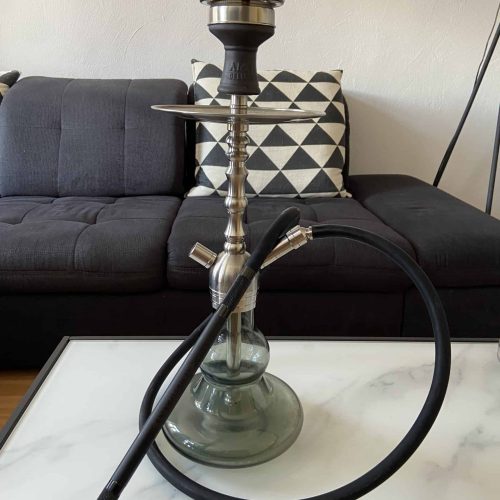 Shisha mit Metall- und Glasbowl auf Tisch, modernes Design.