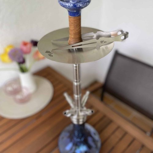 Hookah mit blauer Glasflasche und Zubehör, auf Holztablett.
