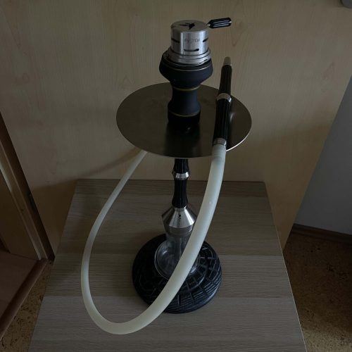Shisha-Kopf mit Glasbowl und Schlauch auf Holztisch.