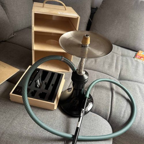 Rauchsäule mit Shisha, Schlauch und Zubehör auf Couch.