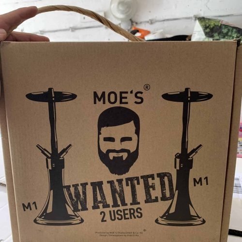 Dekorative Verpackung mit Moe's Wanted M1 Shisha und Gesicht-Design.