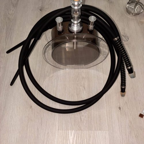 Shisha mit Glasbowl, Schlauch und Zubehör auf Holzboden.