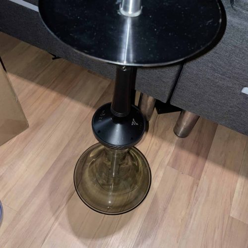 Kleiner runder Beistelltisch mit schwarzer Oberfläche und Glasbasis, ideal für Wohnzimmer oder Loung.