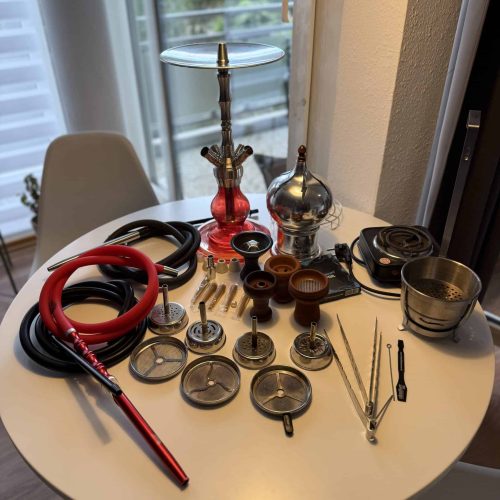 Verschiedene Shisha-Teile und Zubehör auf einem Tisch, bereit für den Verkauf.