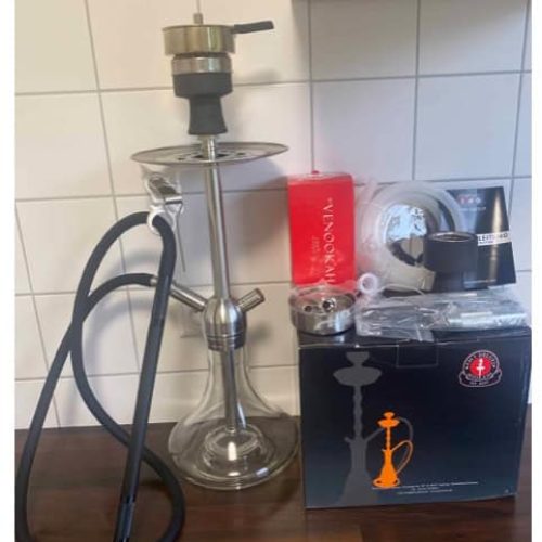Shisha mit Glasbowl, Dampfgerät und Zubehör auf Tisch.