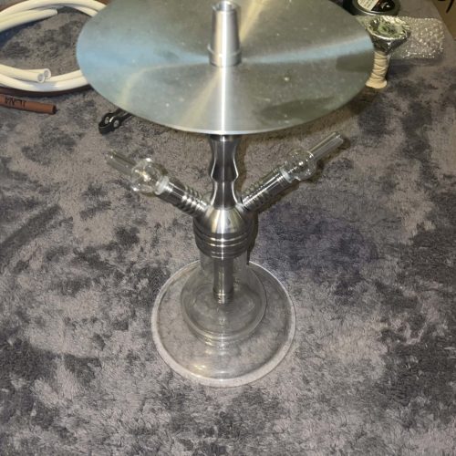 Feuerstelle mit Glasplatte und Metallständer, perfekt für Garten oder Terrasse.