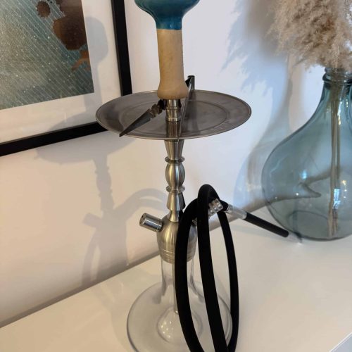 Shisha mit Glasbowl, Schlauch und Kohleteller auf Tisch.