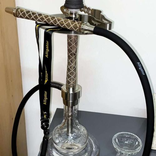 Rauchsäule mit Shisha, Schlauch und Zubehör auf einem Tisch.