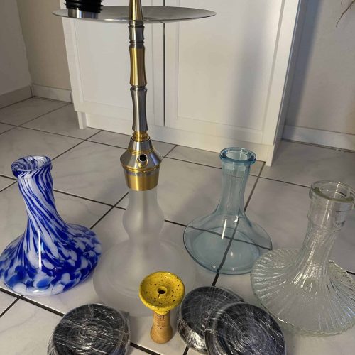 Verschiedene Shisha-Teile und Zubehör auf Fliesenboden.