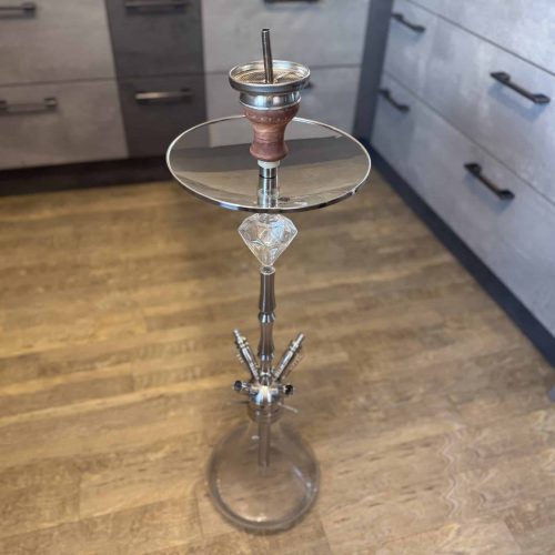 Hookah mit Glasaufsatz auf Holzboden in Küche.