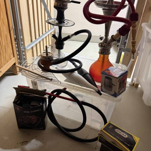 Verschiedene Shisha-Teile und Glasbowl auf einem Tisch.