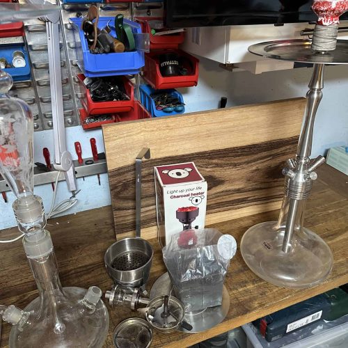 Dekorative Glas-Shisha mit Zubehör und Kohleanzünder.