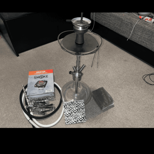 Rauchsäule mit Shisha und Zubehör auf einem Tisch, bereit für den Gebrauch.