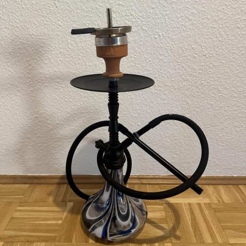 Shisha mit Glasbowl, Schlauch und Metallaufsatz, auf Holzboden.