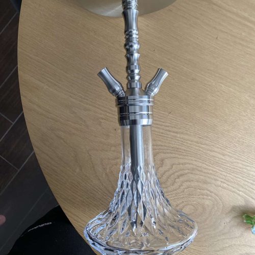 Eleganter Glas- und Metall-Schmuckhaken auf Tisch.
