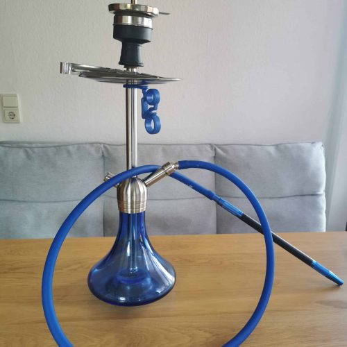 Shisha mit blauer Glasbasis und Silikonschlauch auf Holztisch.