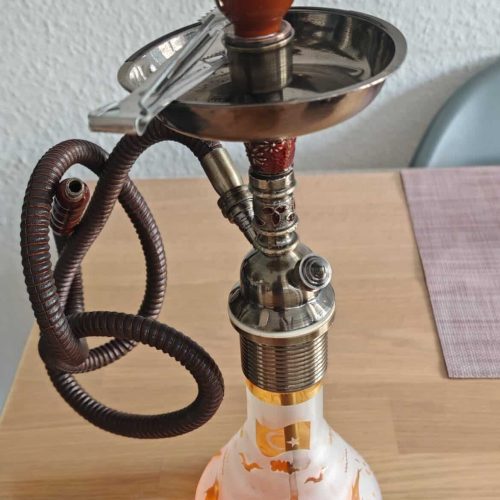 Rauchsäule mit Glasbowl, Schlauch und Metallteilen auf Holztisch.