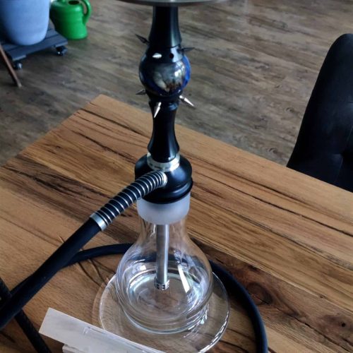 Rauchsäule mit Glas und Metall, Shisha Zubehör, auf einem Holztisch.