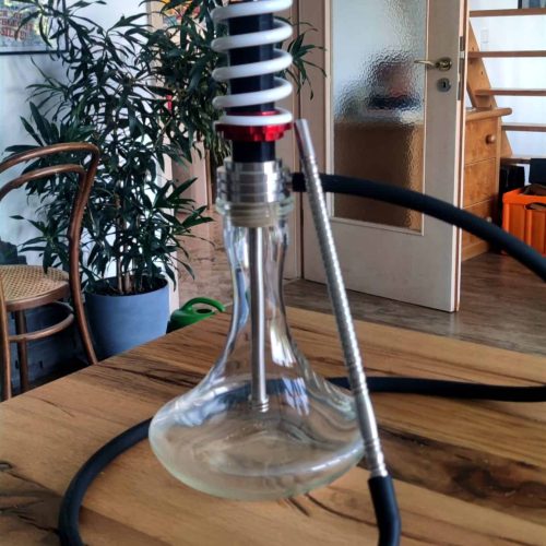 Rauchersäule für Shisha mit Metall- und Glasdesign, auf Holztisch in Innenraum.