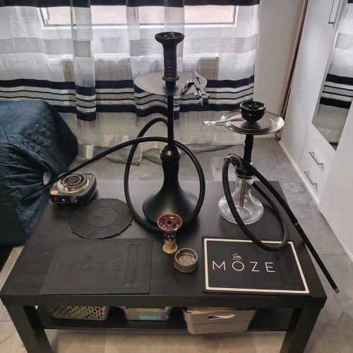 Moderne Shisha mit Glasbowl auf Tisch in Wohnzimmer.