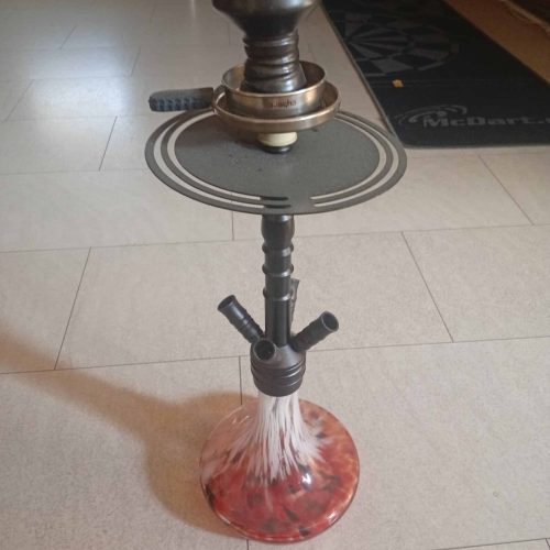 Shisha mit Glasbowl, Schlauch und Ablage auf Boden.