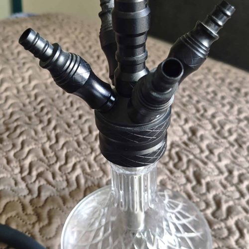 Mehrere schwarze Shisha-Adapter und Schlauchanschlüsse in einer Glasbowl.