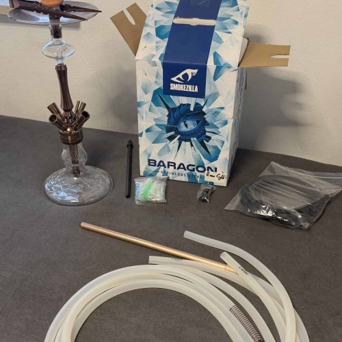 Shisha Glasbowl, Schlauch und Zubehör auf Tisch.