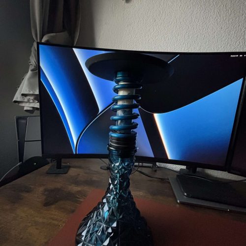 Moderne Keramik-Shisha auf Holztablett mit Bildschirm im Hintergrund.