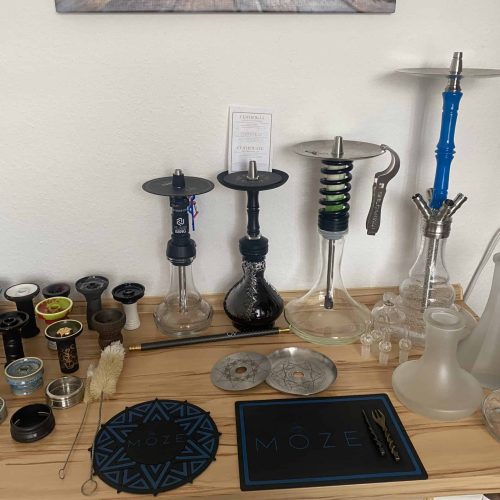 Verschiedene Shisha-Teile und Zubehör auf einem Tisch.