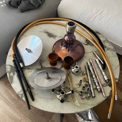Shisha mit Glas, Schläuchen und Zubehör, bereit zum Rauchen.