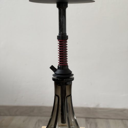 Shisha-Hookah mit Glasbowl und Metallstange auf Holztisch.