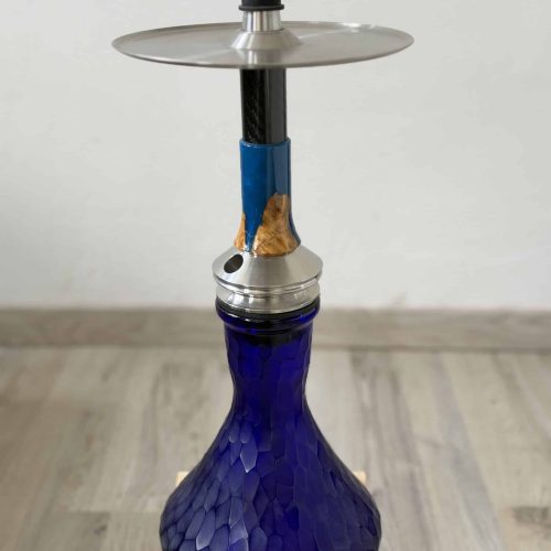 Blaue Glasbowl Shisha mit Metallaufsatz auf Holzblock.