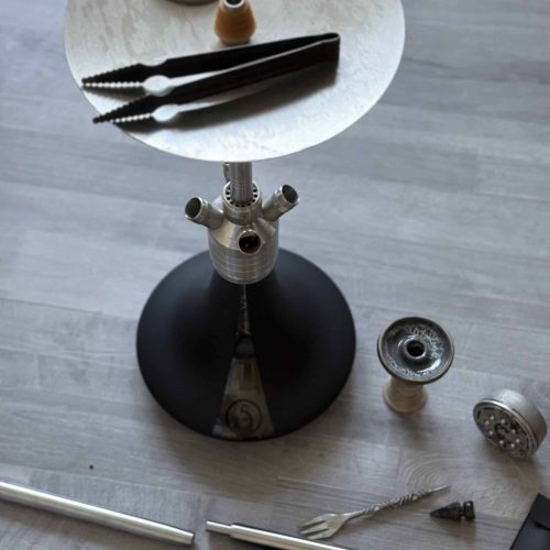 Verschiedene Shisha-Teile und Zubehör auf einem Tisch.
