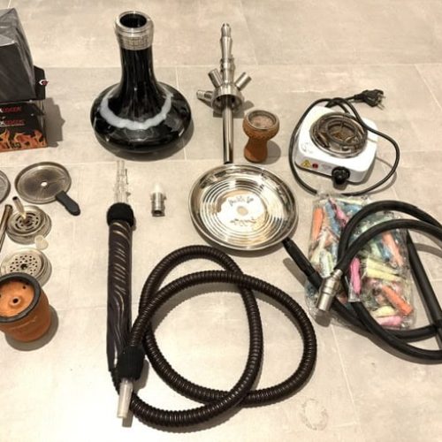 Verschiedene Shisha-Teile und Zubehör auf Boden.