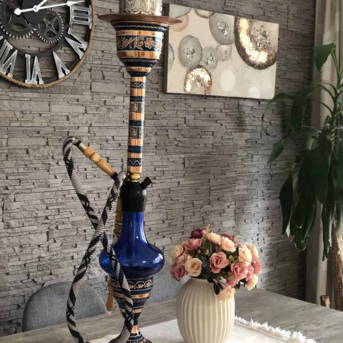 Bunte Shisha mit Muster und Schlauch auf Esstisch.
