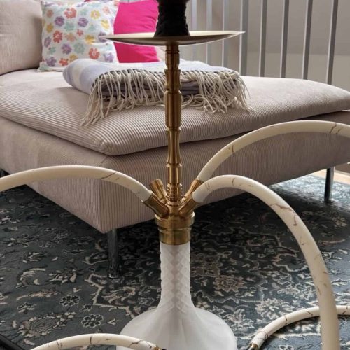Moderne Shisha mit schwarzem Kopf und goldenen Details auf einem weißen Stand.