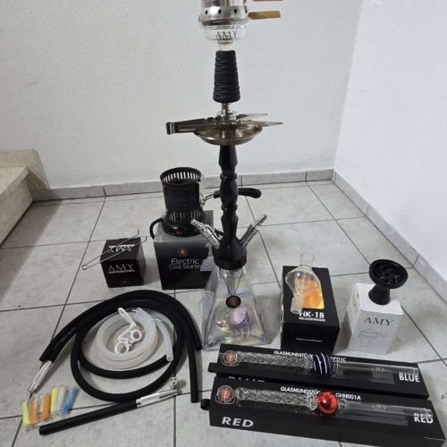 Verschiedene Shisha Teile, inklusive Glasbowl, Schlauch und Kohlezange.