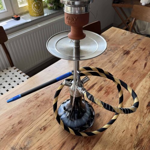 Shisha mit Glasballon, Metall- und Keramikteilen, auf Holztablett.