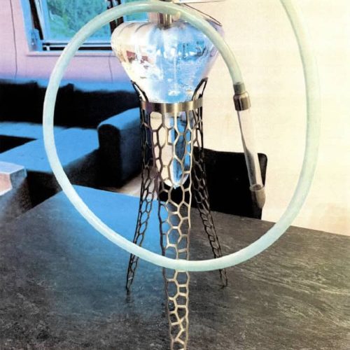 Moderne Shisha mit Glasbowl und Silikonschlauch auf Tisch.