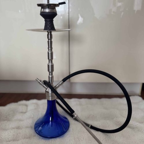 Shisha mit Metallkopf, Schlauch und Ablage, auf weichem Teppich.