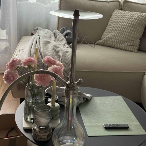 Wasserpfeifenaufsatz auf modernem Wohnzimmer-Tisch, gemütliche Atmosphäre.
