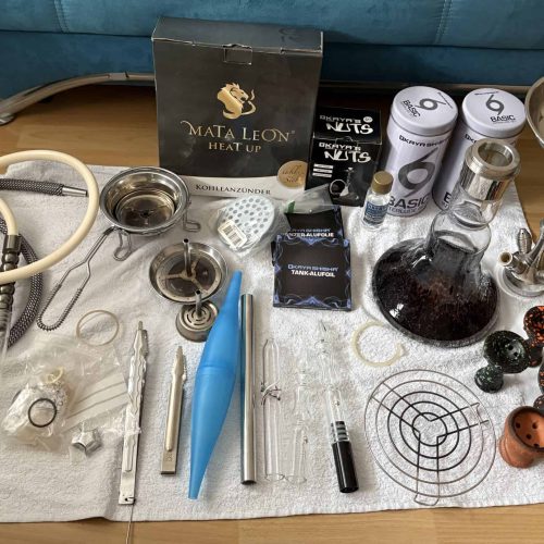 Shisha Glasbowl und Reinigungsteile auf Tisch.